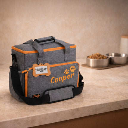 Gray and orange pet travel bag with 'Cooper' branding on a countertop.