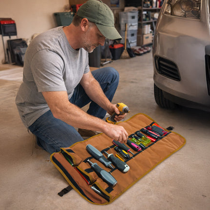 Man organizing tools in a roll-up tool organizer in a garage.