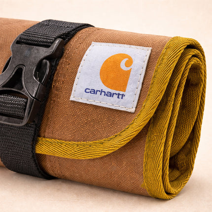 Carhartt roll-up tool bag with visible brand logo on a beige background