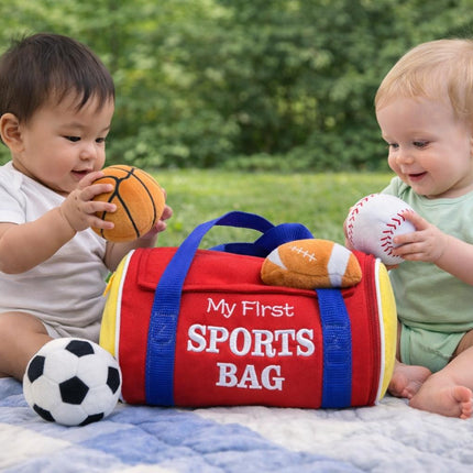 Two children playing with sports balls next to a 'My First Sports Bag' on a grassy field.