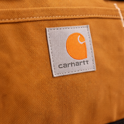 Close-up of a Carhartt logo on a brown fabric surface