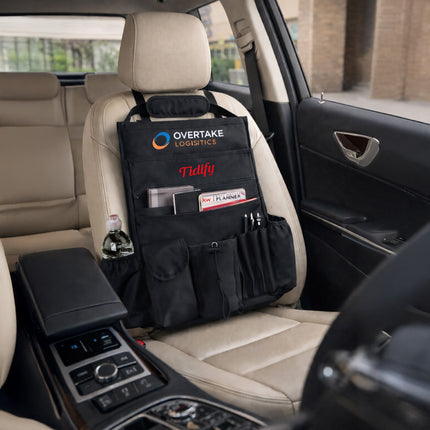 Car organizer with multiple pockets and compartments attached to a car seat.