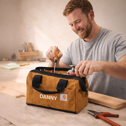 Man using tools from a 'Danny' branded tool bag in a workshop setting.
