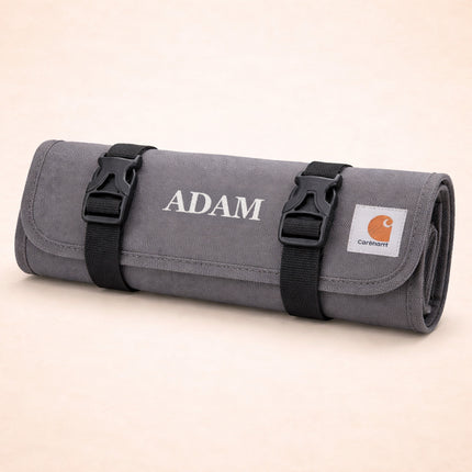 Gray roll-up bag with 'ADAM' branding on a beige background