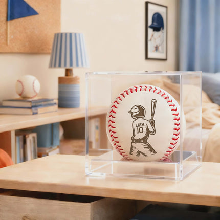Baseball with personalized engraving in a clear display case on a wooden surface.