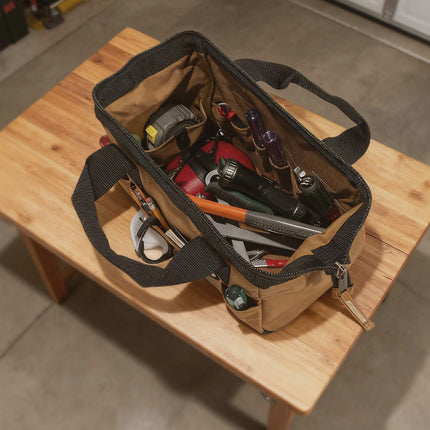 Open tool bag with various tools on a wooden table
