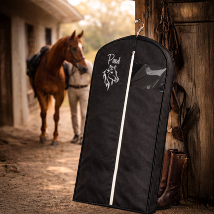 Black garment bag with a horse design in a stable setting