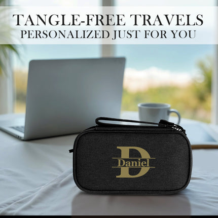 Black travel organizer with 'Daniel' logo on a table with a laptop and cup, text 'Tangle-Free Travels Personalized Just For You'.