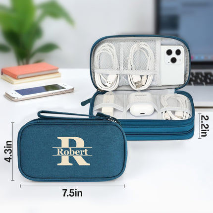 Blue travel organizer with 'Robert' branding, containing electronic accessories on a desk.