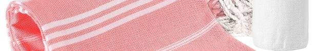 A set of pink and white striped beach towels with custom names embroidered on them, accompanied by a white drawstring storage bag.