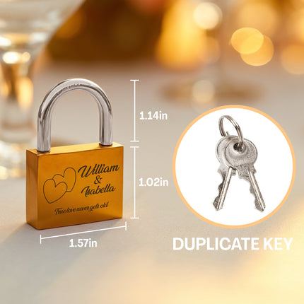 Gold lock with engraved names and dimensions, accompanied by a duplicate key.