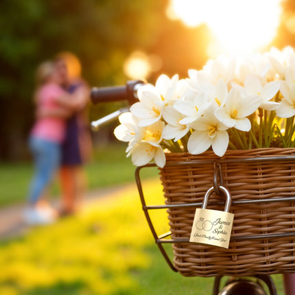 Basket of white flowers with a lock on a bicycle, couple embracing in the background