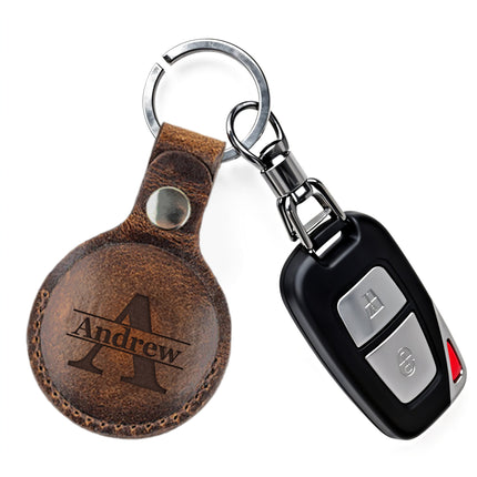 Brown leather keychain with engraved 'Andrew' and a car key fob on a white background