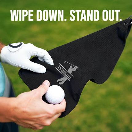 Person holding a golf ball and black towel with a logo
