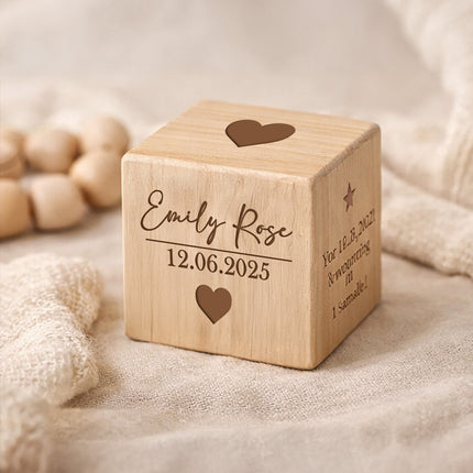 Wooden cube with engraved text and hearts on a soft fabric background