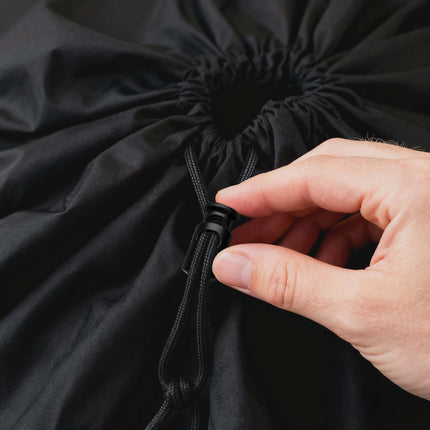Hand tying a black drawstring bag