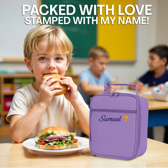 Child eating a sandwich with a purple lunch bag labeled 'Samuel' in a classroom setting.