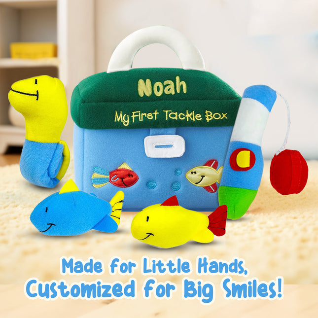 Children's toy tackle box with plush fish and a name tag on a wooden surface.