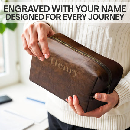 Brown leather pouch with 'Henry' engraved, held by a person in a light-colored sweater.