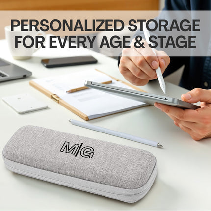 Gray pencil case with 'MG' logo on a desk with stationery items and text about personalized storage.
