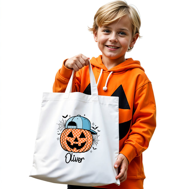 Child holding a white tote bag with a Halloween design and name 'Oliver' on a white background
