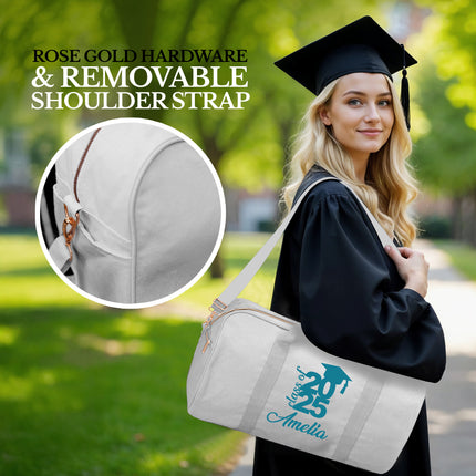 Graduate holding a white bag with 'Amelia' branding, rose gold hardware, and removable shoulder strap.

