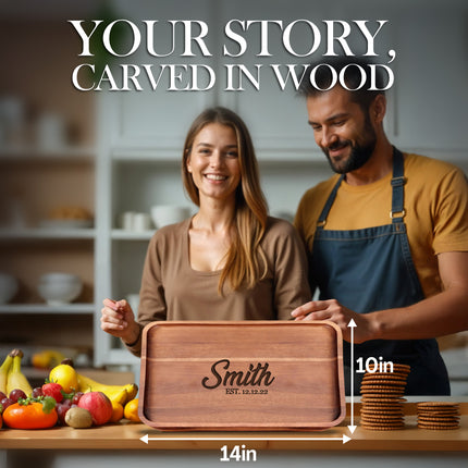 Man and woman with a wooden cutting board engraved with 'Smith' in a kitchen setting.