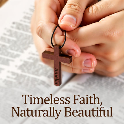 Wooden cross pendant with 'Amelia' engraved, held by hands on a textured fabric background with text 'Timeless Faith, Naturally Beautiful'.